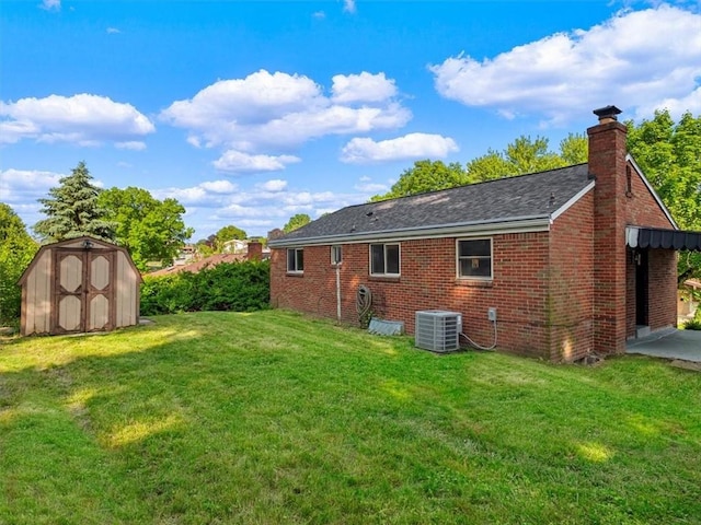 612 Blossom Dr, Baldwin Boro, PA 15236 - back of house featuring central air condition unit, a lawn, brick siding, a chimney, and a shingled roof