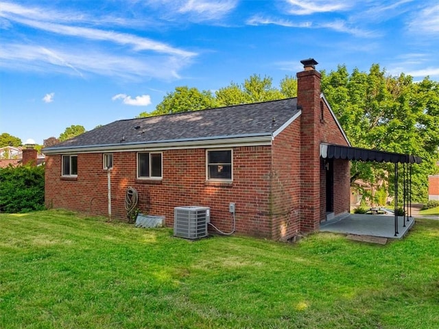 612 Blossom Dr, Baldwin Boro, PA 15236 - back of property with central AC unit, a lawn, a chimney, and brick siding