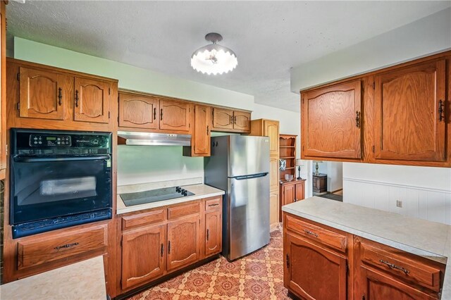 1011 S Lake Rd, Jefferson Twp Mer, PA 16137 - kitchen featuring black appliances, under cabinet range hood, light countertops, and brown cabinets