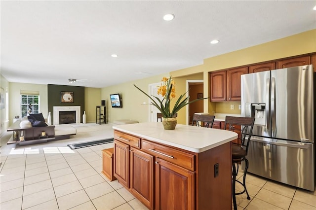 4324 Grandview Dr, Richland, PA 15044 - kitchen with stainless steel refrigerator with ice dispenser, light tile patterned flooring, a kitchen island, a kitchen bar, and a fireplace