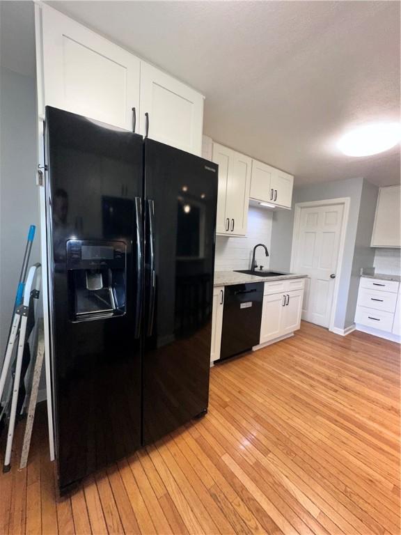 2693 Crosby Ave, Dormont, PA 15216 - kitchen with black appliances, a sink, light wood-style flooring, white cabinets, and light countertops