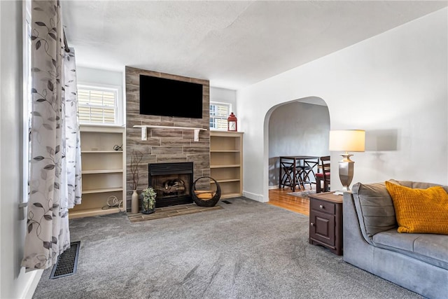 2693 Crosby Ave, Dormont, PA 15216 - carpeted living area featuring arched walkways, a tiled fireplace, and baseboards