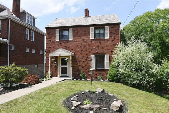21 Leon Rd, Green Tree, PA 15220 - view of front of house featuring a chimney, a front yard, a high end roof, and brick siding