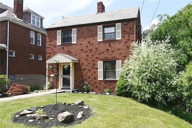 21 Leon Rd, Green Tree, PA 15220 - view of front of house with a chimney, a front lawn, brick siding, and a high end roof