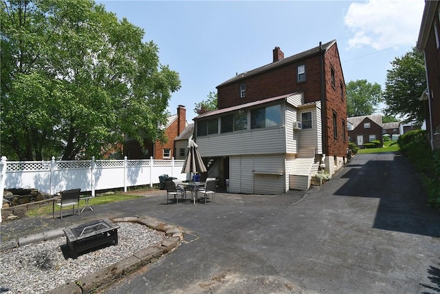 21 Leon Rd, Green Tree, PA 15220 - rear view of property featuring an outdoor fire pit, a patio, and a chimney