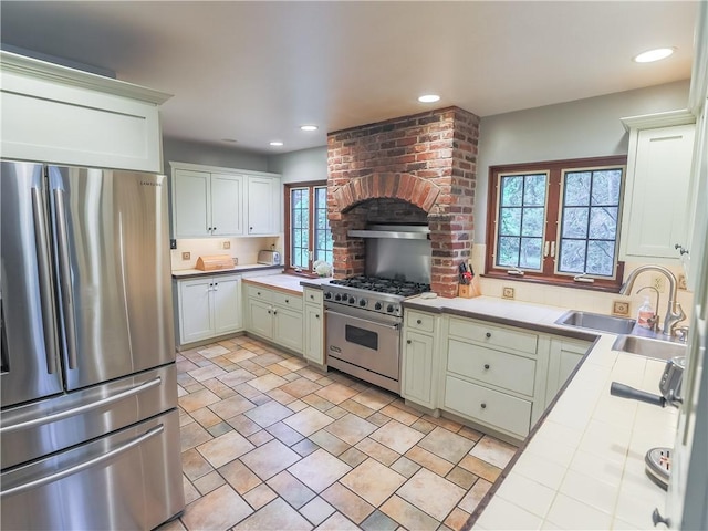 464 Avon Dr, Mt Lebanon, PA 15228 - kitchen with stainless steel appliances, tile counters, a sink, recessed lighting, and wall chimney exhaust hood