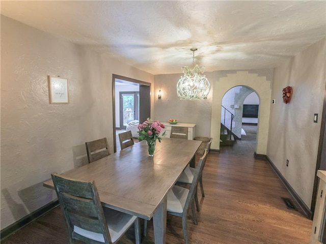 464 Avon Dr, Mt Lebanon, PA 15228 - dining space with arched walkways, wood finished floors, a chandelier, a textured wall, and baseboards
