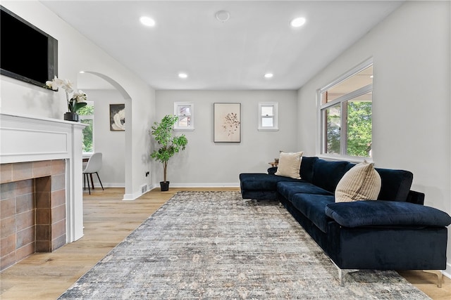 1416 Swantek St, Sheraden, PA 15204 - living area featuring arched walkways, recessed lighting, light wood-style flooring, a tile fireplace, and baseboards
