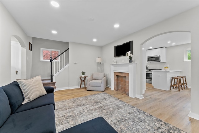 1416 Swantek St, Sheraden, PA 15204 - living room featuring arched walkways, light wood-style flooring, stairs, baseboards, and recessed lighting