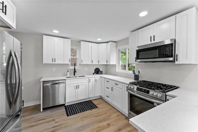 1416 Swantek St, Sheraden, PA 15204 - kitchen featuring appliances with stainless steel finishes, a sink, light wood-style flooring, white cabinetry, and recessed lighting