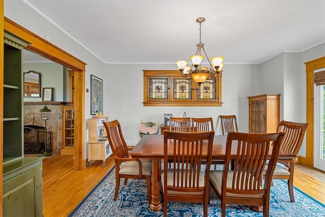 2352 Beaufort Ave, Brookline, PA 15226 - dining space featuring a chandelier, light wood-style floors, ornamental molding, and a fireplace