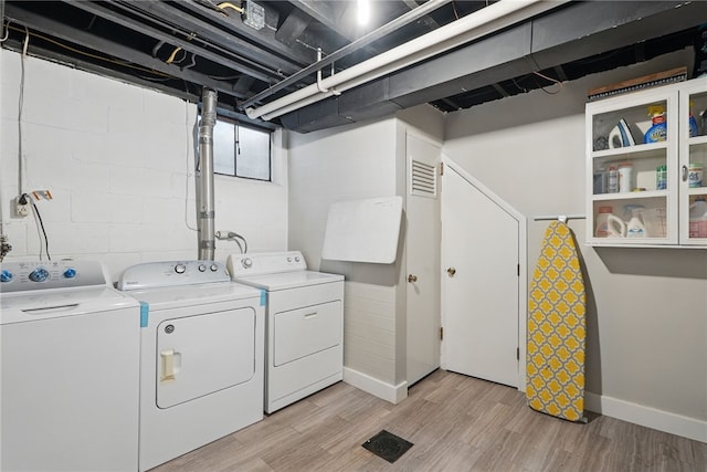 1450 Mohican Dr, Mt Lebanon, PA 15228 - laundry area with washer and dryer, light wood-style floors, baseboards, and concrete block wall