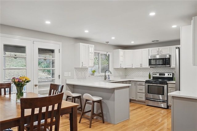 1450 Mohican Dr, Mt Lebanon, PA 15228 - kitchen with stainless steel appliances, a peninsula, a sink, backsplash, and recessed lighting