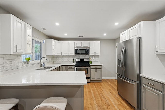 1450 Mohican Dr, Mt Lebanon, PA 15228 - kitchen featuring stainless steel appliances, a sink, recessed lighting, light wood-type flooring, and light countertops
