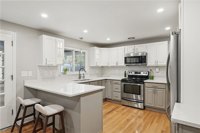 1450 Mohican Dr, Mt Lebanon, PA 15228 - kitchen featuring stainless steel appliances, a sink, a peninsula, decorative backsplash, and recessed lighting