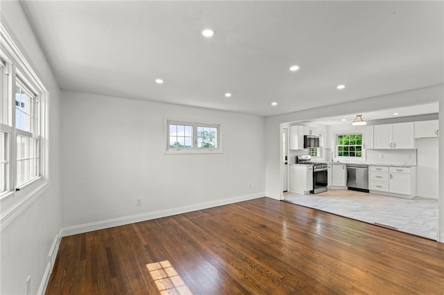 5360 California Ave, Bethel Park, PA 15102 - unfurnished living room featuring healthy amount of natural light, baseboards, light wood-style floors, recessed lighting, and a sink