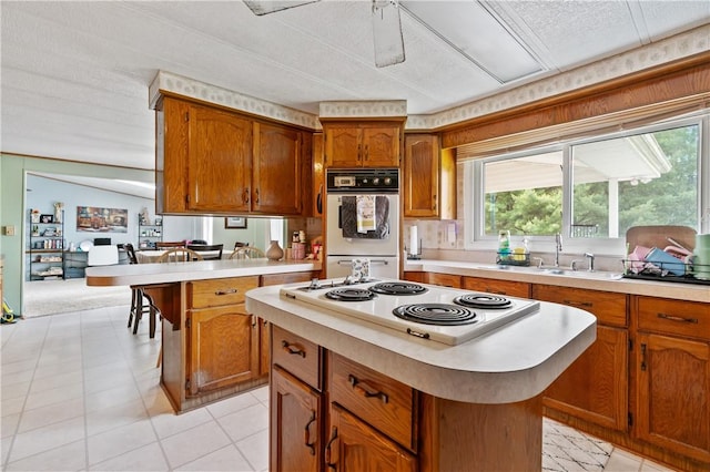 4041 Second St, Hempfield Twp Wml, PA 15642 - kitchen featuring white appliances, light countertops, brown cabinetry, a center island, and a textured ceiling