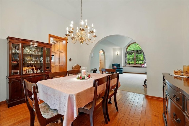 79 Mariacher Rd, Findley Twp, PA 16137 - dining room featuring arched walkways, a chandelier, light wood-style floors, baseboards, and lofted ceiling