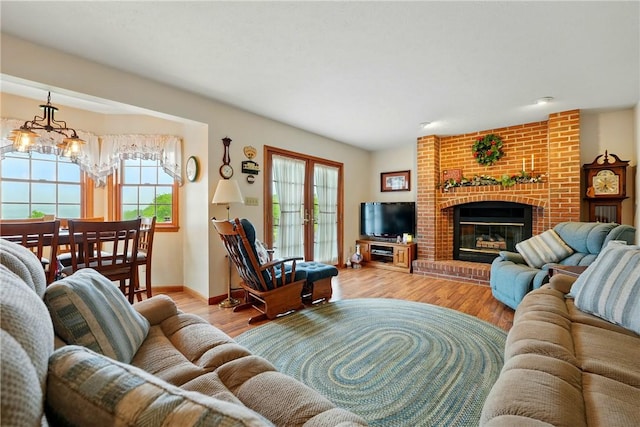 79 Mariacher Rd, Findley Twp, PA 16137 - living room with a chandelier, light wood-type flooring, a fireplace, and baseboards