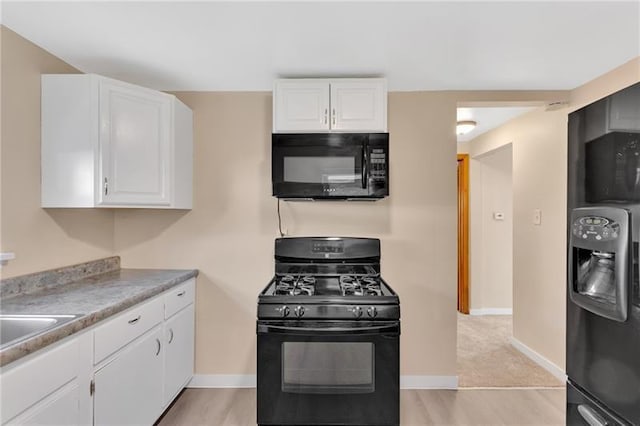 427 Cedar St, Jeannette, PA 15644 - kitchen featuring black appliances, white cabinets, baseboards, and light wood-type flooring