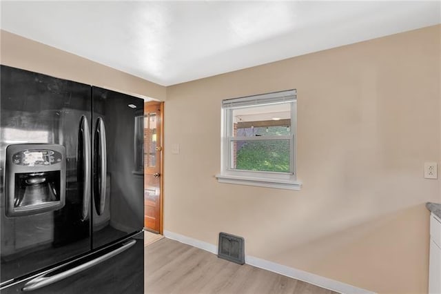 427 Cedar St, Jeannette, PA 15644 - kitchen with black fridge, baseboards, and light wood-type flooring
