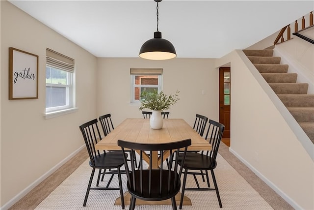 427 Cedar St, Jeannette, PA 15644 - dining space with baseboards, stairway, and light carpet