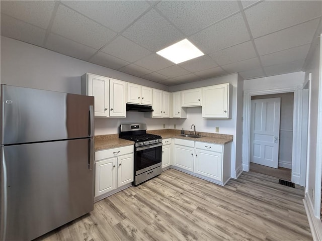 610 Southern Ave, Mt Washington, PA 15211 - kitchen featuring appliances with stainless steel finishes, a sink, a drop ceiling, under cabinet range hood, and white cabinets