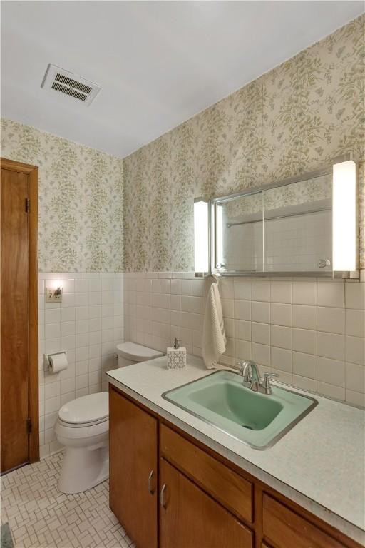 17 Lakeview Dr, Lackawannock Twp, PA 16159 - bathroom with vanity, tile walls, wallpapered walls, toilet, and tile patterned floors