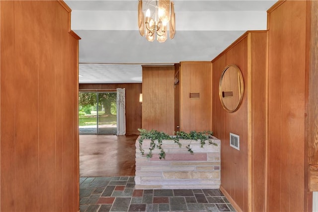 17 Lakeview Dr, Lackawannock Twp, PA 16159 - foyer entrance featuring wooden walls, a chandelier, and dark stone finish flooring