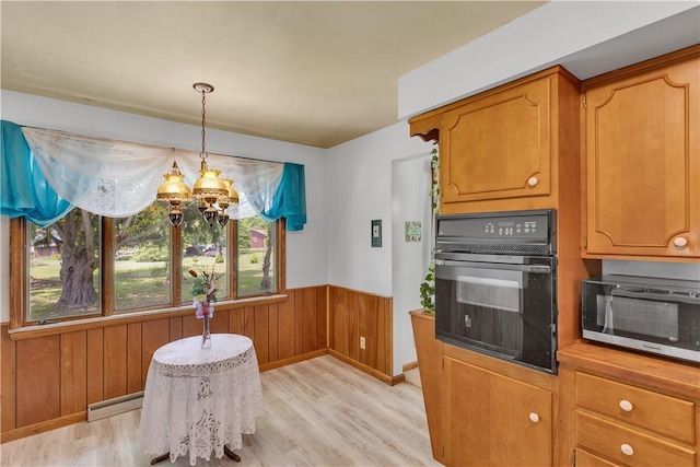 17 Lakeview Dr, Lackawannock Twp, PA 16159 - kitchen featuring black oven, light wood-style flooring, stainless steel microwave, a wainscoted wall, and a baseboard heating unit