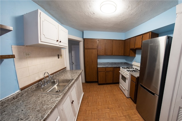 222-224 Alice St, Mount Oliver, PA 15210 - kitchen featuring freestanding refrigerator, white gas stove, a sink, a textured ceiling, and white cabinets