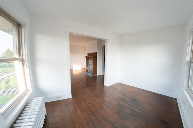 222-224 Alice St, Mount Oliver, PA 15210 - empty room featuring radiator heating unit, baseboards, dark wood finished floors, and a fireplace with flush hearth