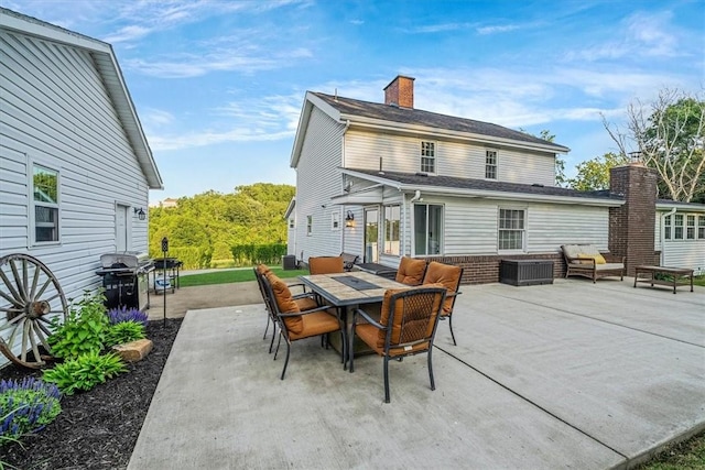 126 Scholl Ln, Rostraver, PA 15012 - back of property featuring an outdoor living space, a patio area, outdoor dining space, and a chimney