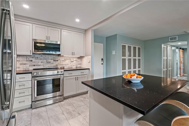 611 N Calais Dr Unit 4212, Mccandless, PA 15237 - kitchen featuring stainless steel appliances, tasteful backsplash, a breakfast bar area, a center island, and dark stone counters
