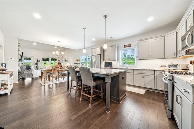 137 Summer Ln, Mount Pleasant Twp Was, PA 15057 - kitchen featuring appliances with stainless steel finishes, recessed lighting, light stone countertops, dark wood-style flooring, and a breakfast bar area