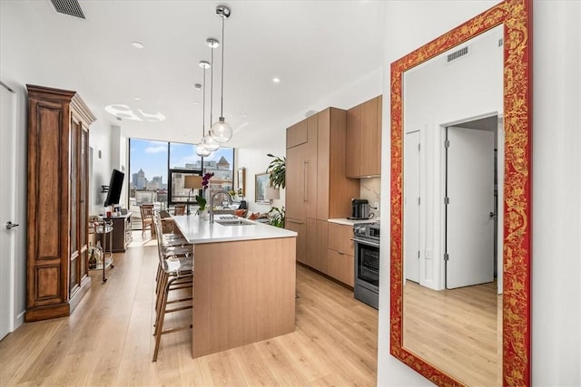 2554 Smallman St Unit 406, Downtown Pgh, PA 15222 - kitchen featuring a sink, modern cabinets, light wood finished floors, a center island with sink, and recessed lighting