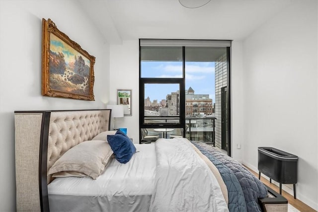 2554 Smallman St Unit 406, Downtown Pgh, PA 15222 - bedroom featuring a wall of windows, wood finished floors, a view of city, baseboards, and access to exterior