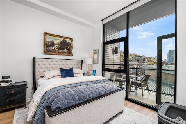 2554 Smallman St Unit 406, Downtown Pgh, PA 15222 - bedroom with multiple windows, wood finished floors, a wall of windows, and access to exterior