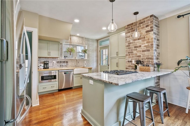 1403 Creedmoor Ave, Brookline, PA 15226 - kitchen featuring stainless steel appliances, a peninsula, a kitchen bar, a sink, and light wood-style floors