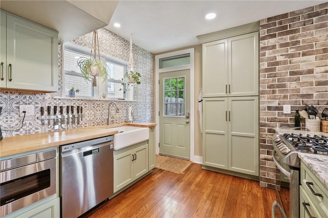 1403 Creedmoor Ave, Brookline, PA 15226 - kitchen featuring appliances with stainless steel finishes, a sink, light wood finished floors, wallpapered walls, and butcher block countertops