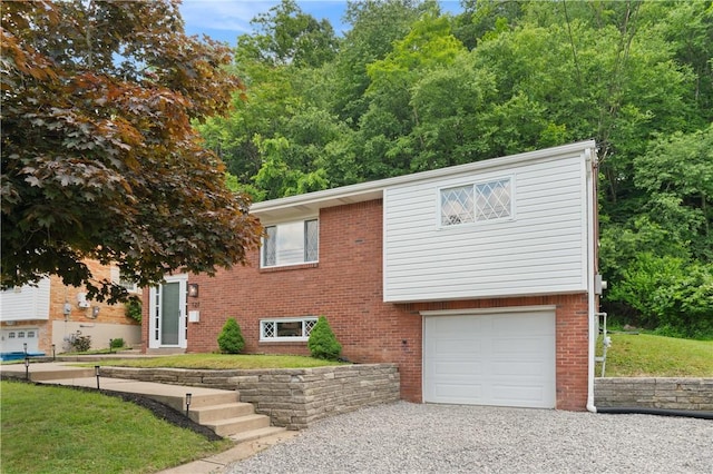 127 Greenview Dr, Penn Hills, PA 15147 - view of front of property with an attached garage, gravel driveway, and brick siding