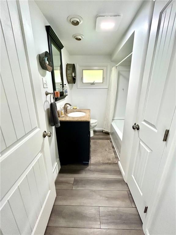 206 Richards Dr, Derry Twp, PA 15650 - full bathroom with toilet, vanity, wood finished floors, and shower / bath combo with shower curtain