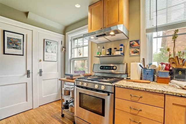 5304 Saint James Ter, Shadyside, PA 15232 - kitchen featuring gas stove, under cabinet range hood, light wood finished floors, and light stone counters
