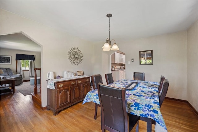 801 4th St N, Versailles, PA 15137 - dining area with light wood-style flooring, a chandelier, and baseboards