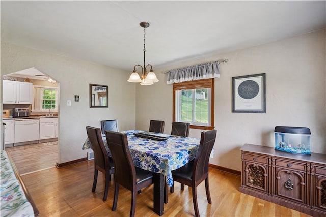 801 4th St N, Versailles, PA 15137 - dining space with light wood-type flooring, a chandelier, and baseboards