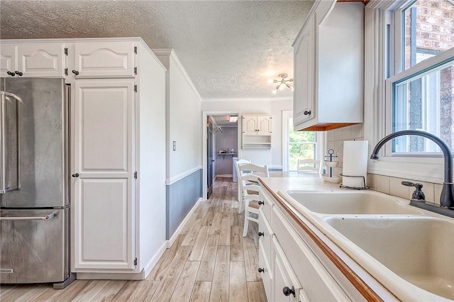 4822 W State St, Mahoning Twp Law, PA 16116 - kitchen featuring high end refrigerator, a sink, light wood-style floors, white cabinets, and a textured ceiling