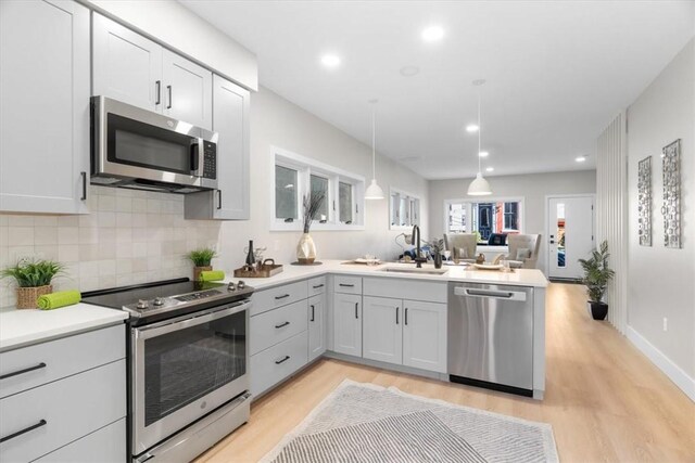 1213 Boyle St, Central North Side, PA 15212 - kitchen with stainless steel appliances, a sink, a peninsula, light wood-type flooring, and recessed lighting
