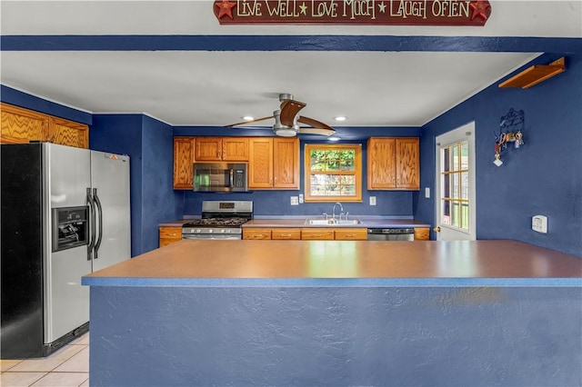 582 Brinwood Ave, Baldwin Boro, PA 15227 - kitchen featuring stainless steel appliances, light tile patterned floors, a sink, ceiling fan, and brown cabinetry