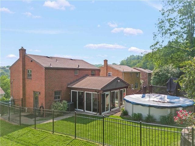 582 Brinwood Ave, Baldwin Boro, PA 15227 - rear view of house with a sunroom, brick siding, central air condition unit, and a chimney
