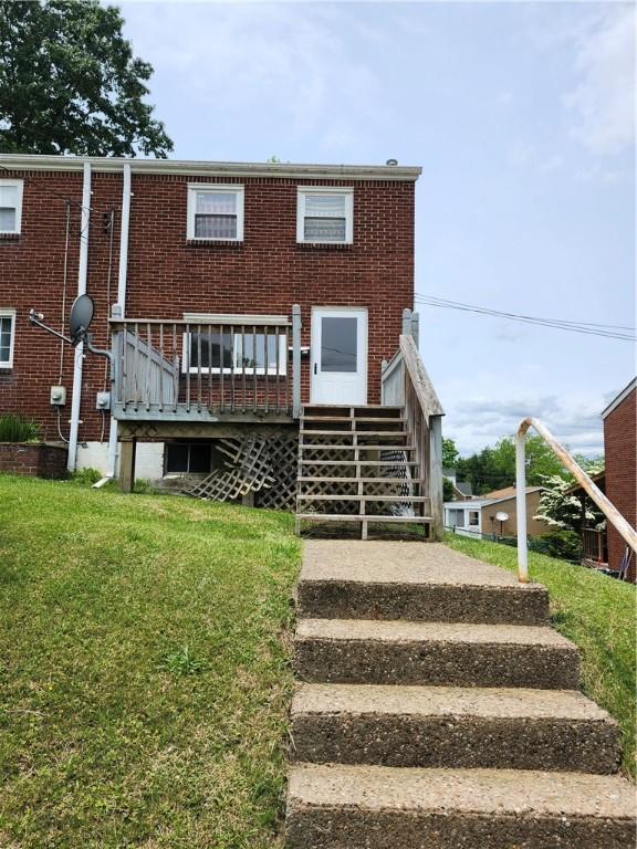 305 Charles Ter, Jeannette, PA 15644 - rear view of property with stairway, a wooden deck, brick siding, and a lawn